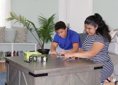 Two students playing a board game at a table